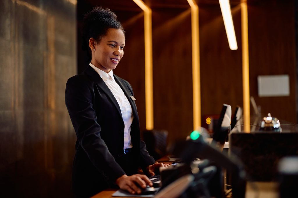 Nachtreceptionist aan de balie tijdens een nachtdienst in een hotel, bezig met administratieve taken en gastenservice