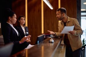 Hotelgast leest zijn klachten voor aan hotelreceptie